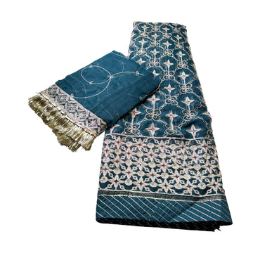 Blue embroidered fabric with intricate patterns on a white background