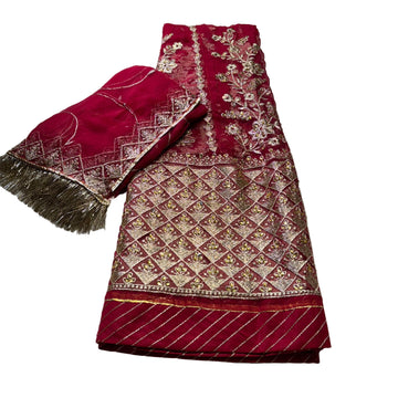 Red embroidered fabric with gold patterns on a light gray background