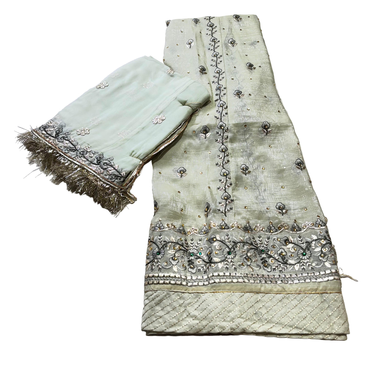 Light green embroidered fabric with decorative patterns on a light gray background