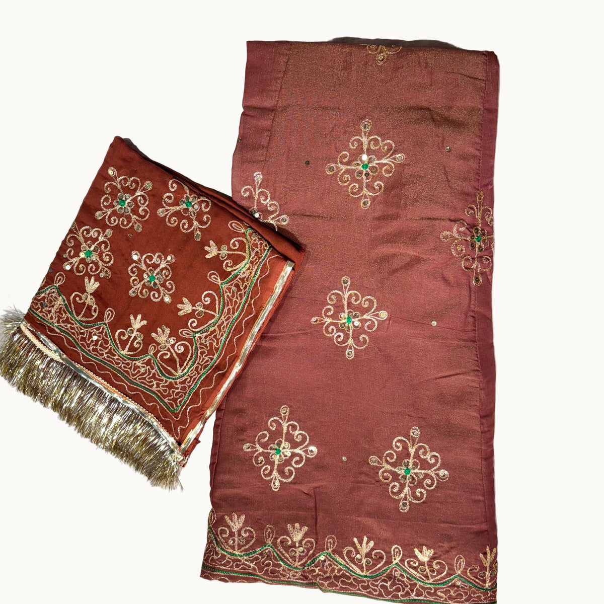 Brown fabric with intricate gold and green embroidery on a light gray background
