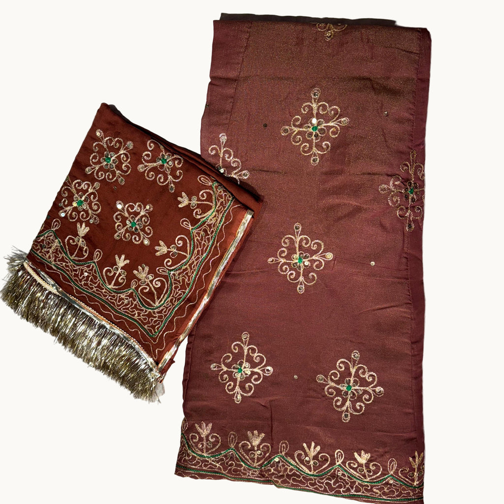 Brown fabric with intricate gold and green embroidery on a light gray background