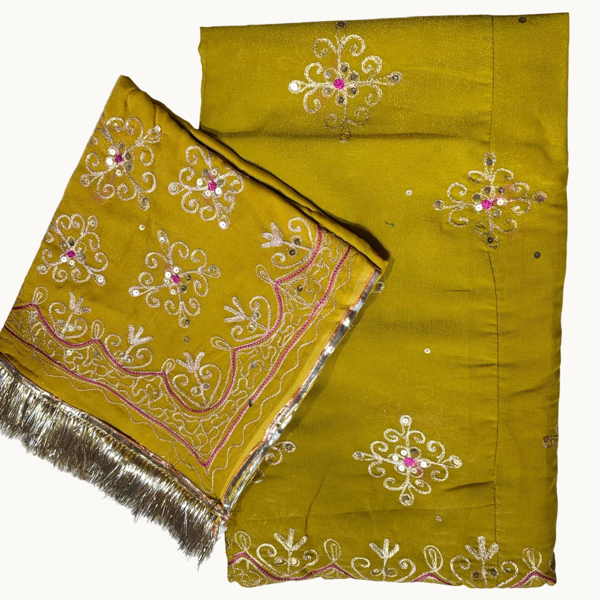 Mustard yellow fabric with intricate white and pink embroidery on a white background