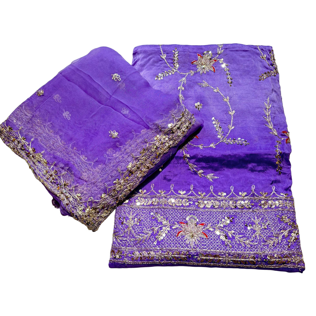 Purple fabric with intricate gold embroidery on a light gray background