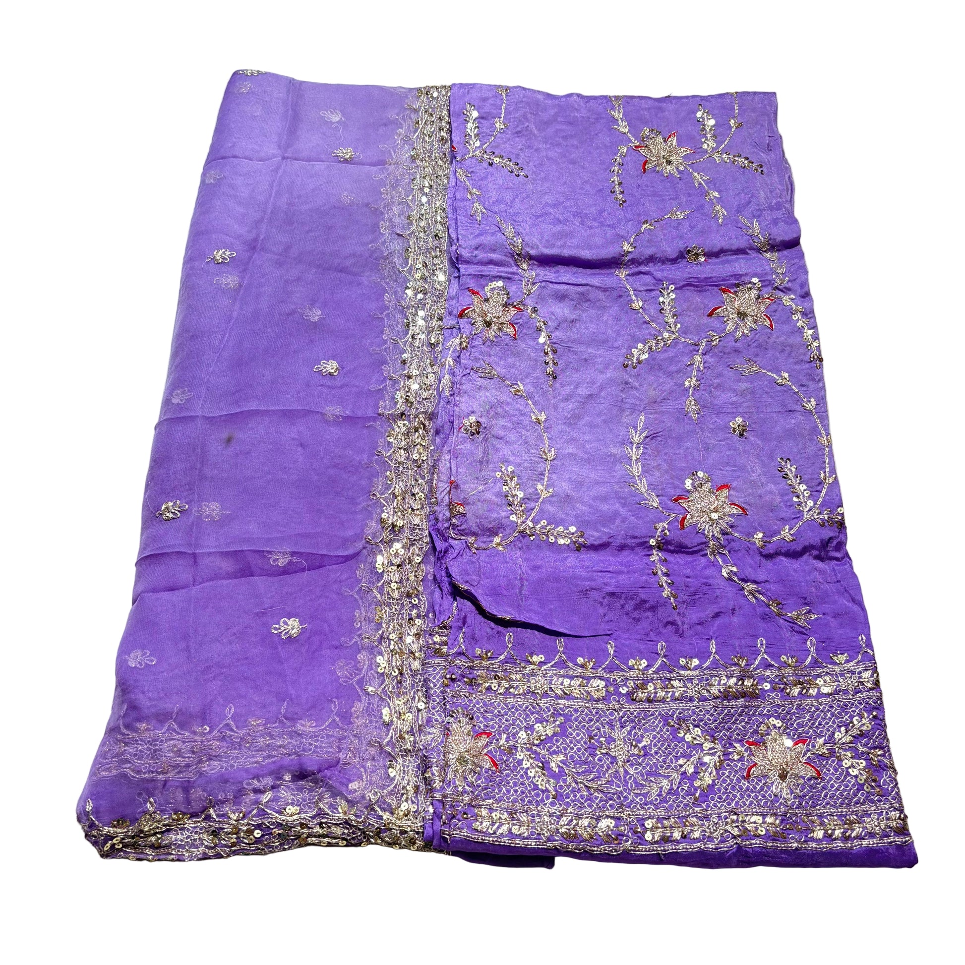 Purple fabric with intricate silver embroidery on a light gray surface