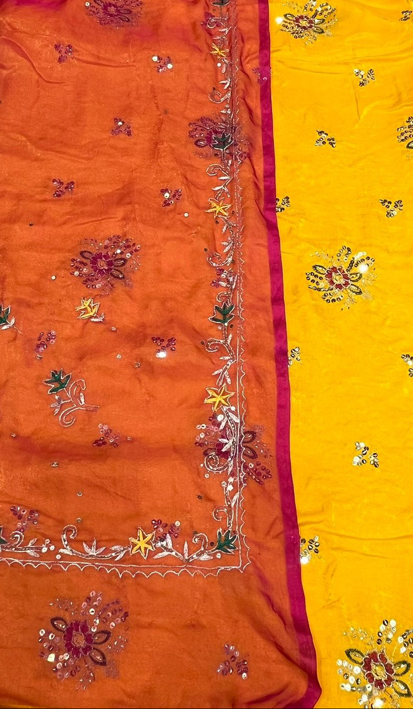 Orange and yellow sarees with floral embroidery on a plain background