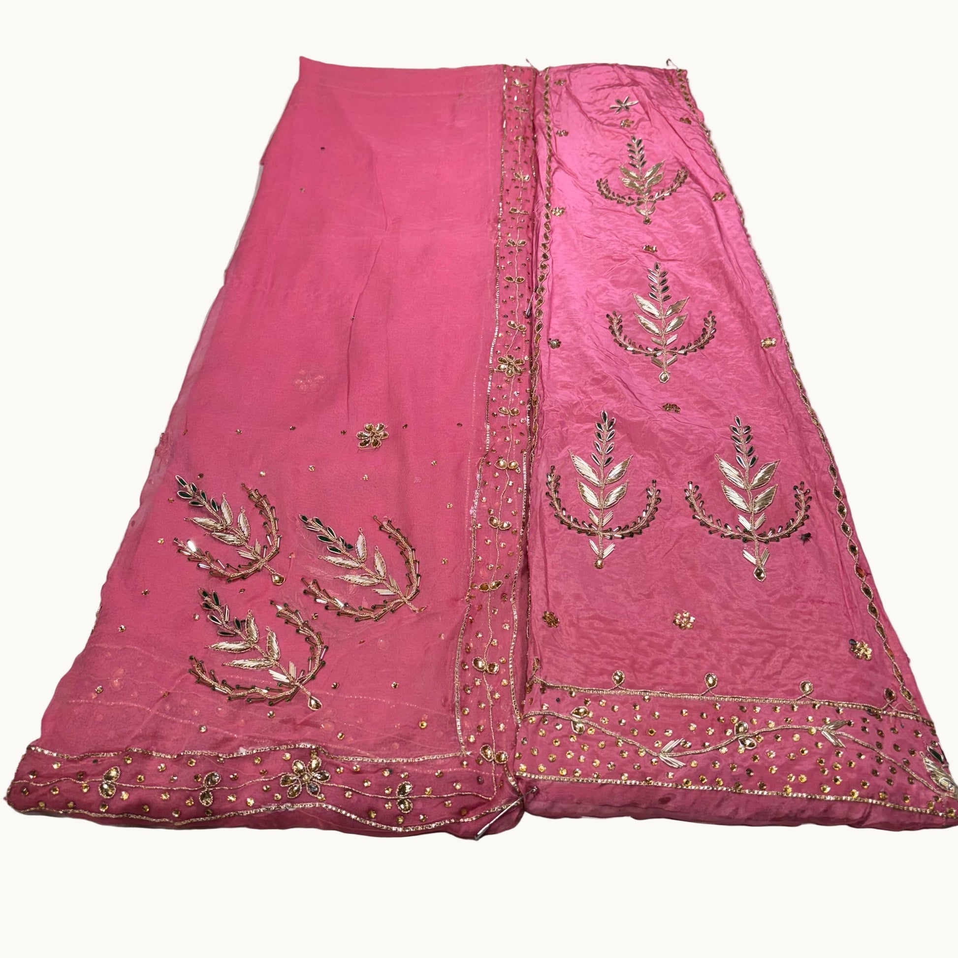Pink embroidered fabric on a light gray background