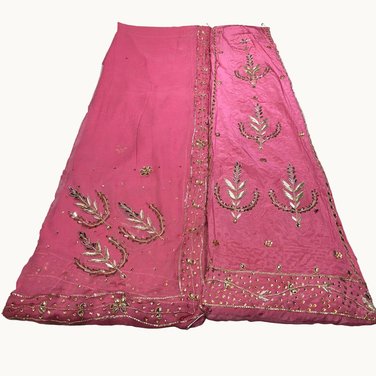 Pink embroidered fabric on a light gray background