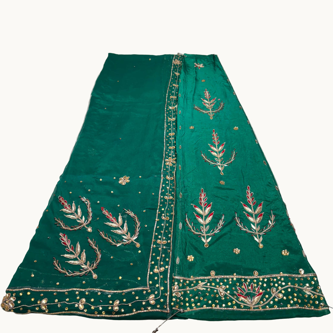 Red embroidered fabric on a white surface
