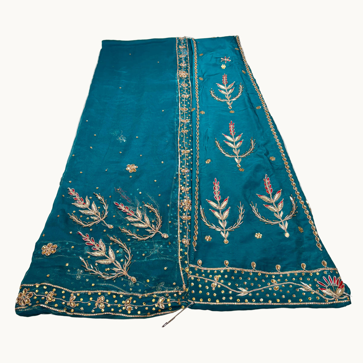Teal embroidered fabric on a light gray background