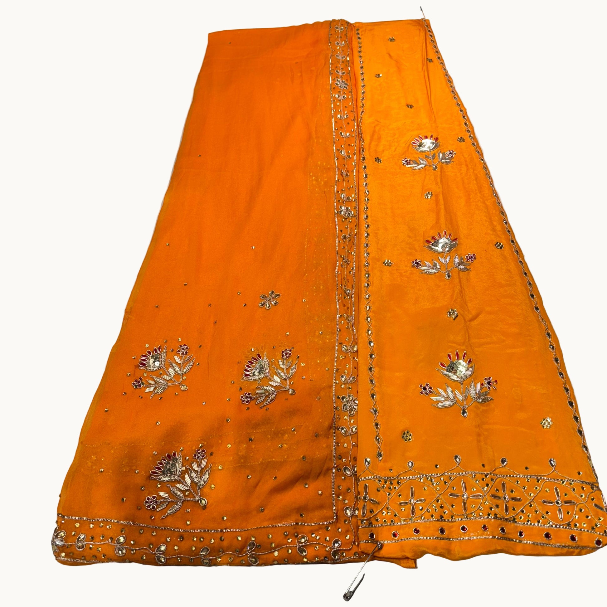 Orange fabric with silver embroidery on a white background