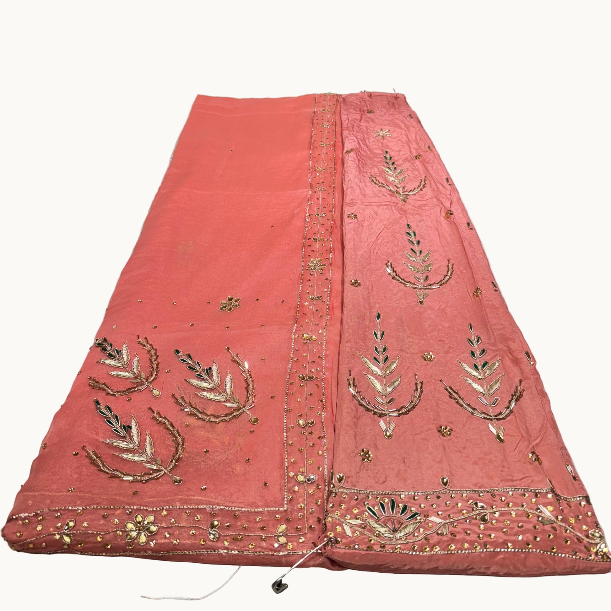 Red fabric with gold embroidery on a white surface