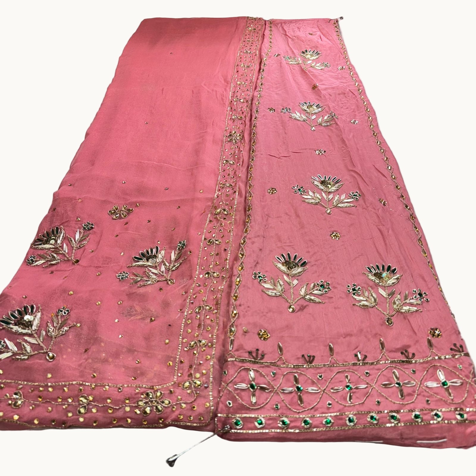Pink fabric with gold embroidery on a white background
