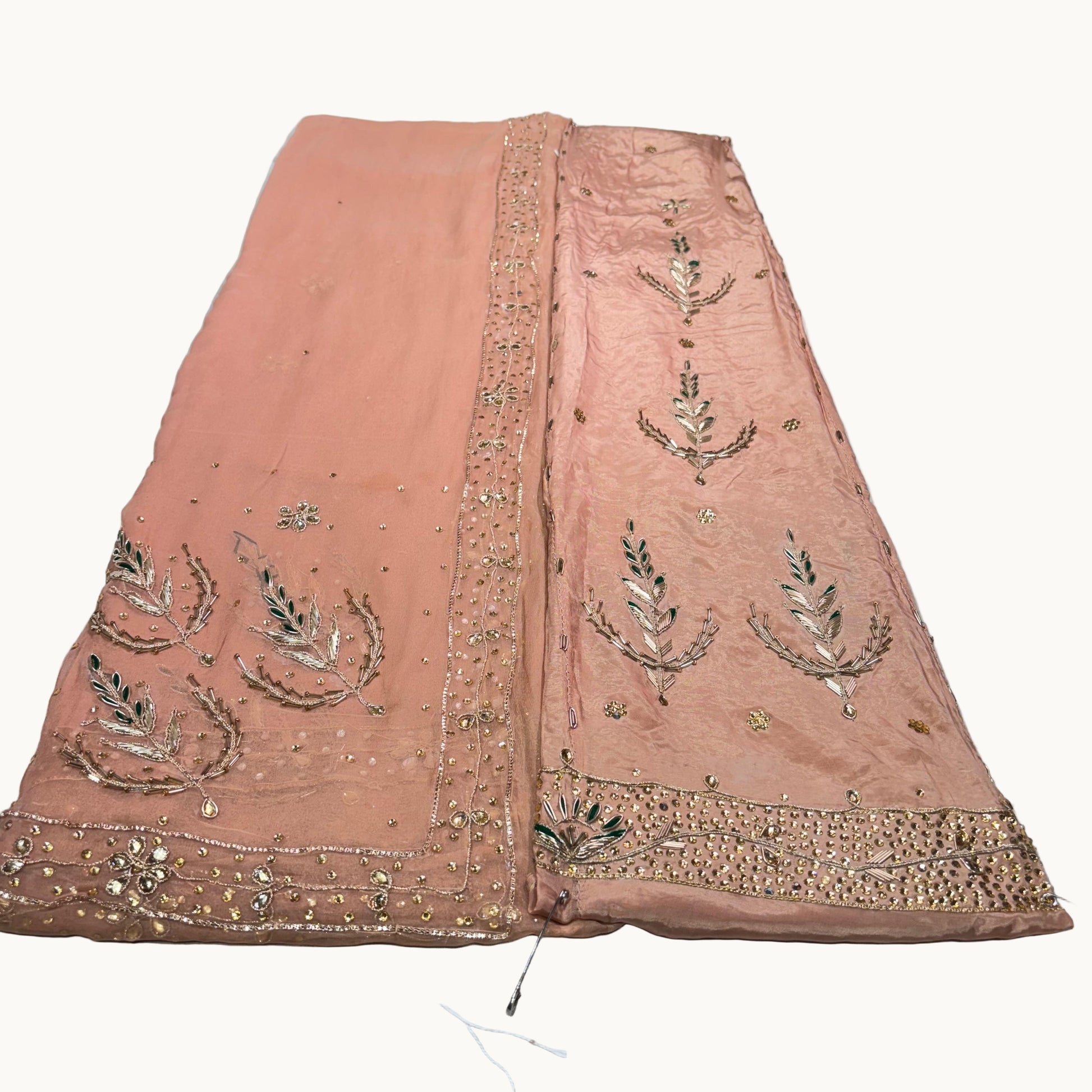 Pink embroidered fabric on a white surface