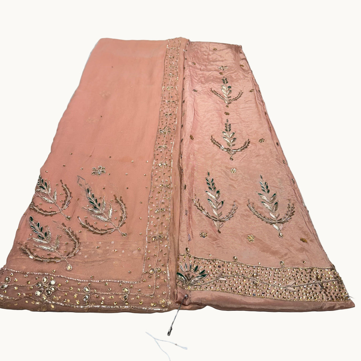 Pink embroidered fabric on a white surface