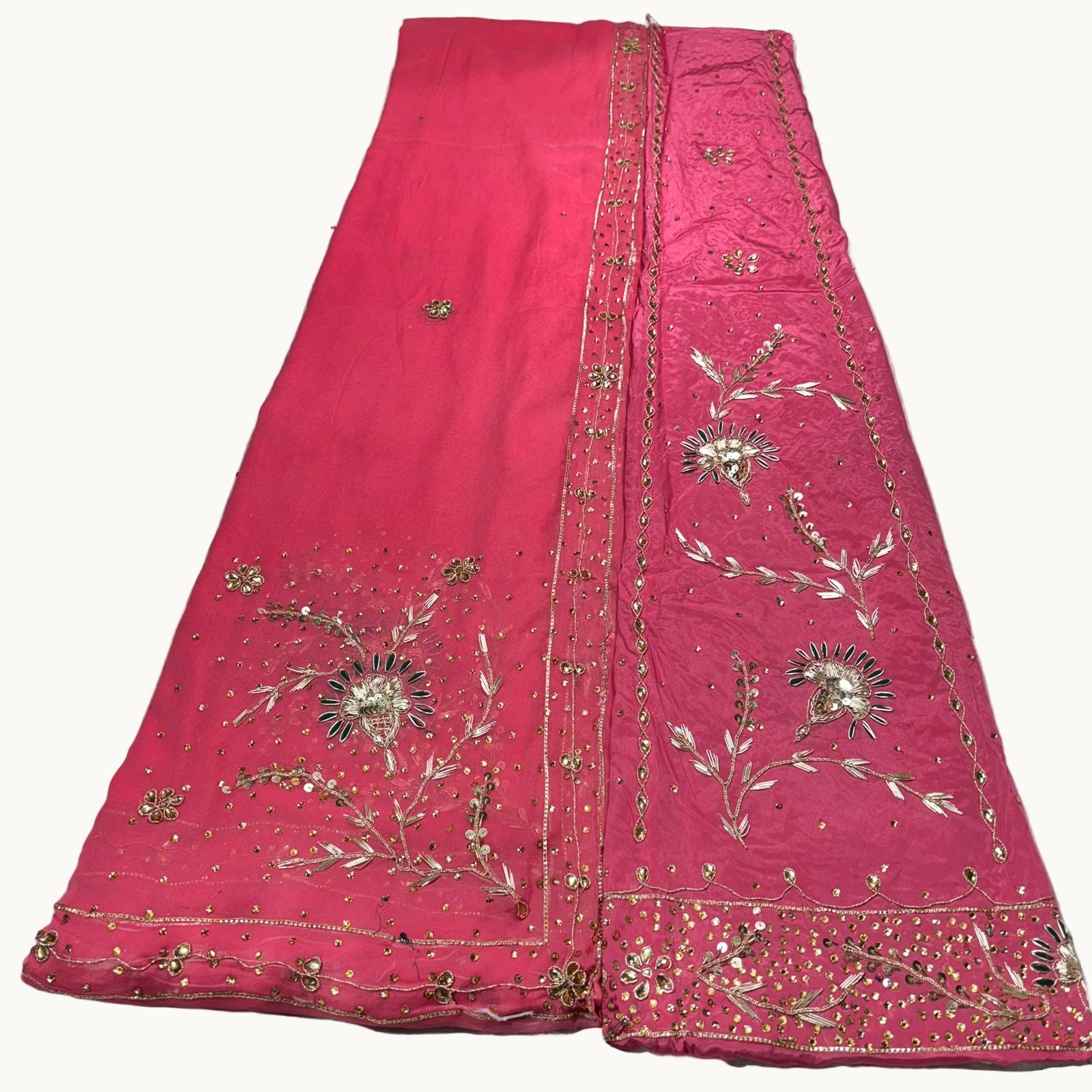 Pink embroidered fabric on a light gray background