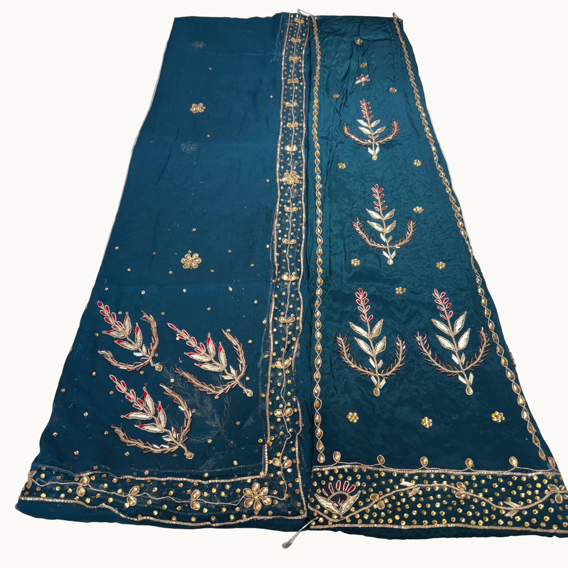 Blue embroidered fabric with gold detailing on a white background