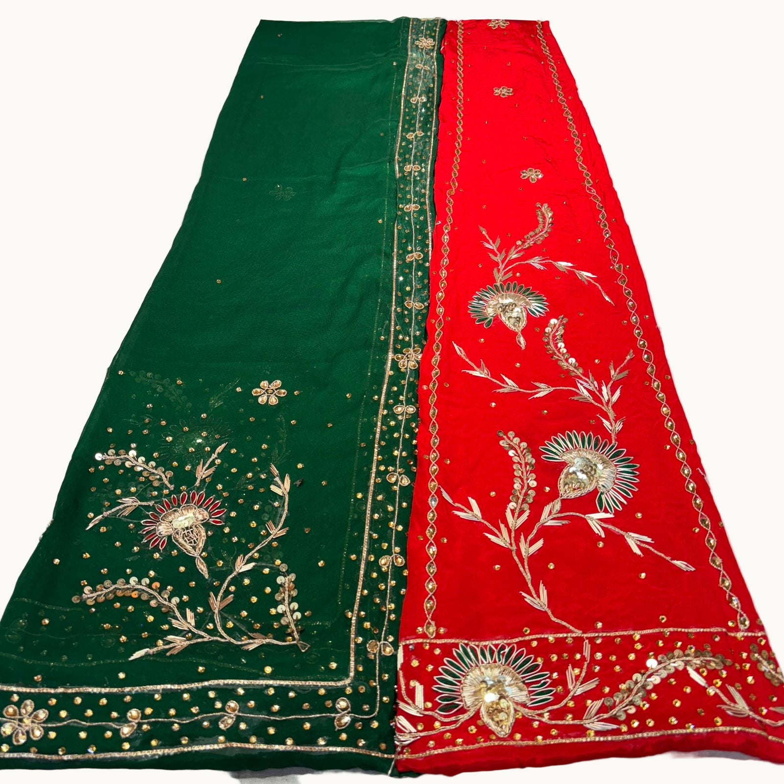 Green and red embroidered fabric with floral patterns on a white surface