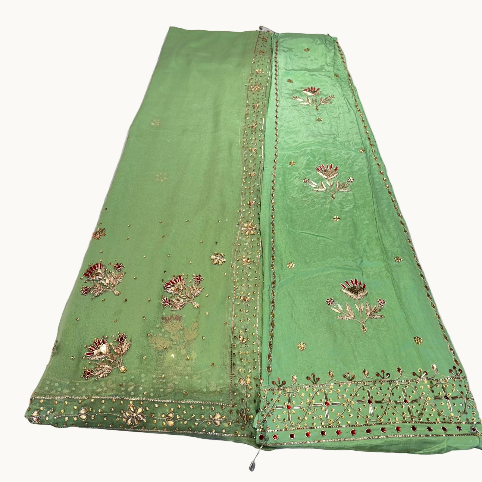 Green embroidered fabric on a white surface