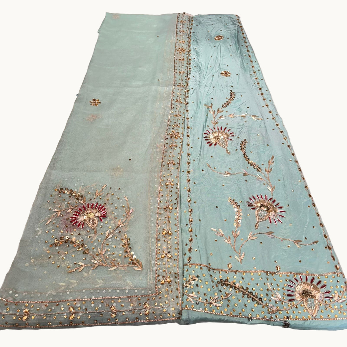 Light blue fabric with gold embroidery on a light gray background