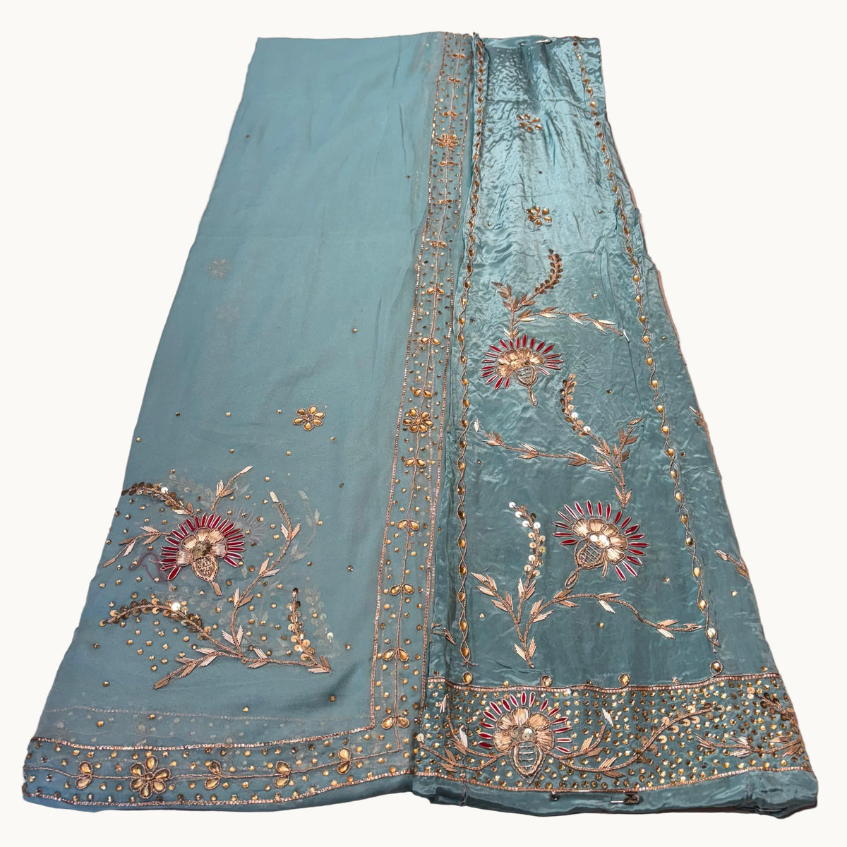 Teal fabric with floral embroidery on a light gray background