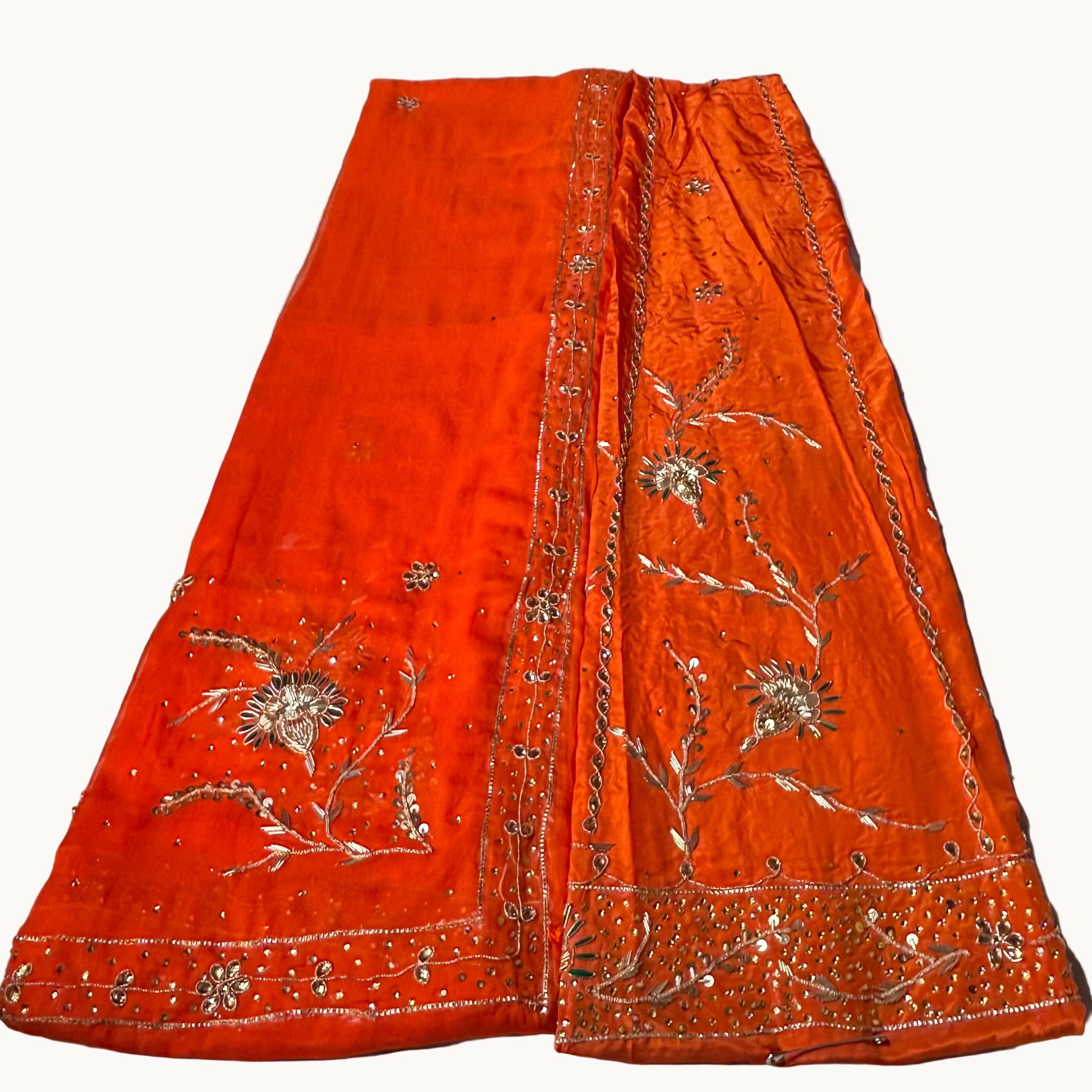 Orange embroidered fabric on a light-colored surface