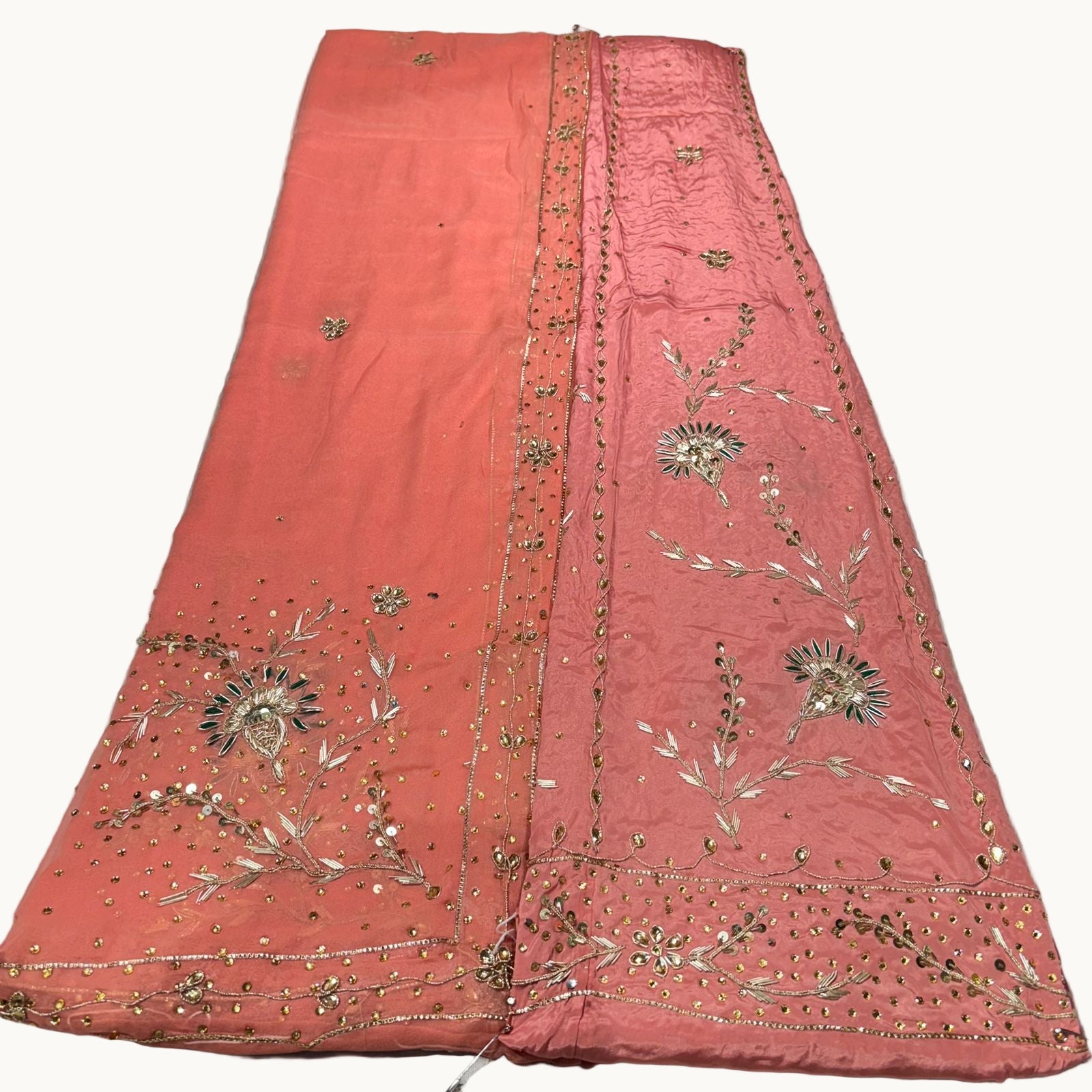 Pink embroidered fabric on a light gray surface