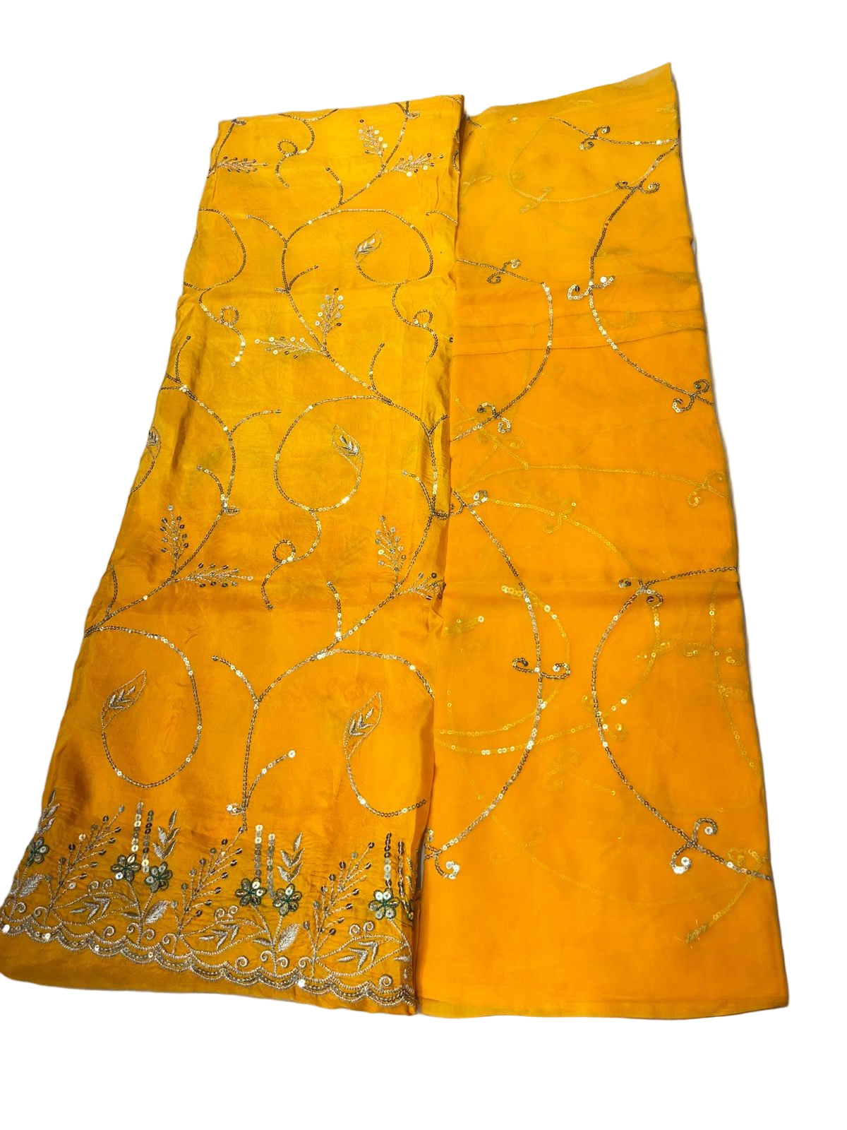 Yellow fabric with intricate gold patterns on a light gray surface