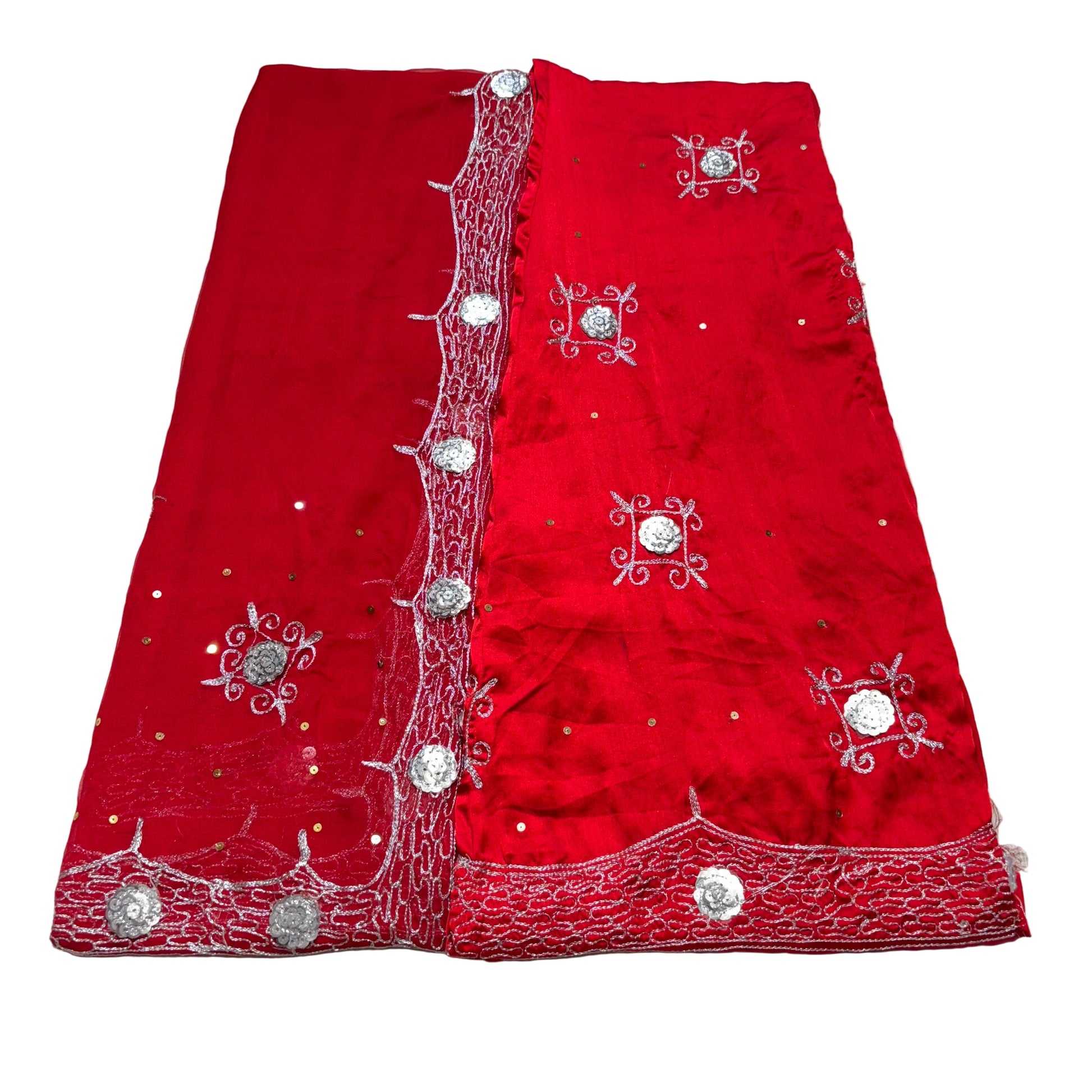 Red fabric with silver embroidery on a beige surface