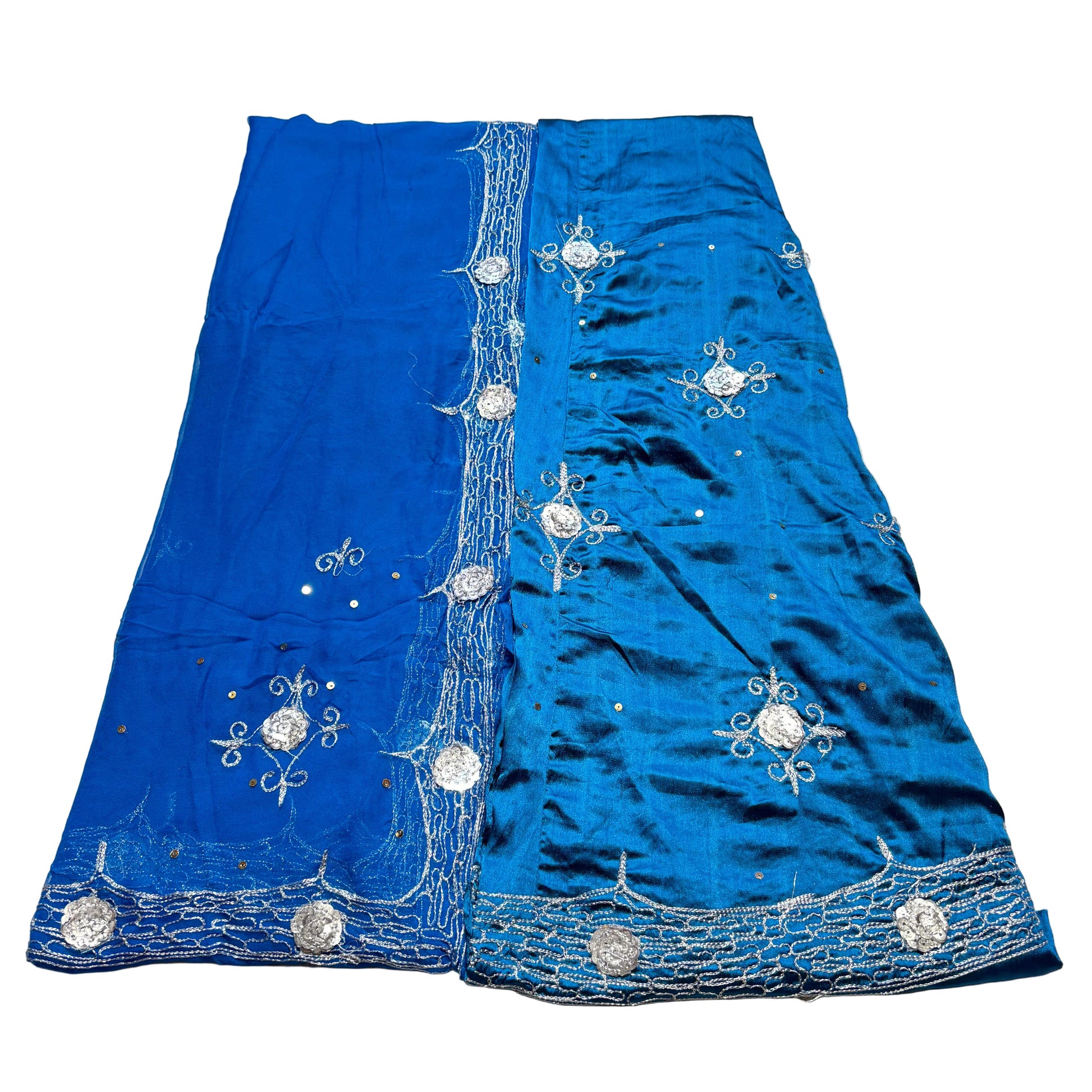 Blue fabric with silver embroidery on a beige surface