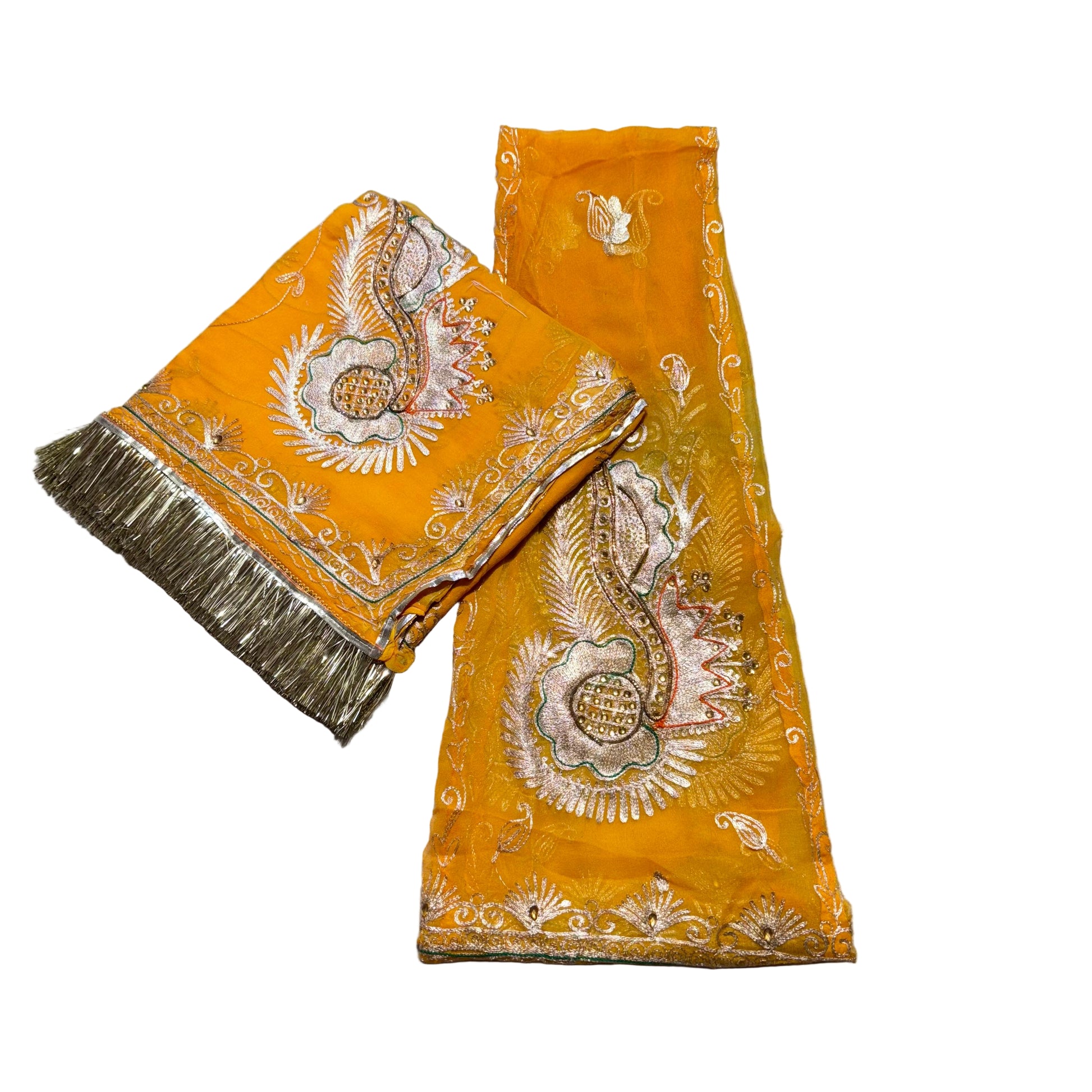 Yellow fabric with intricate white embroidery on a gray surface