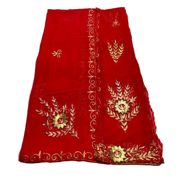 Red fabric with gold embroidery on a light beige background