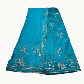 Blue embroidered fabric on a white surface