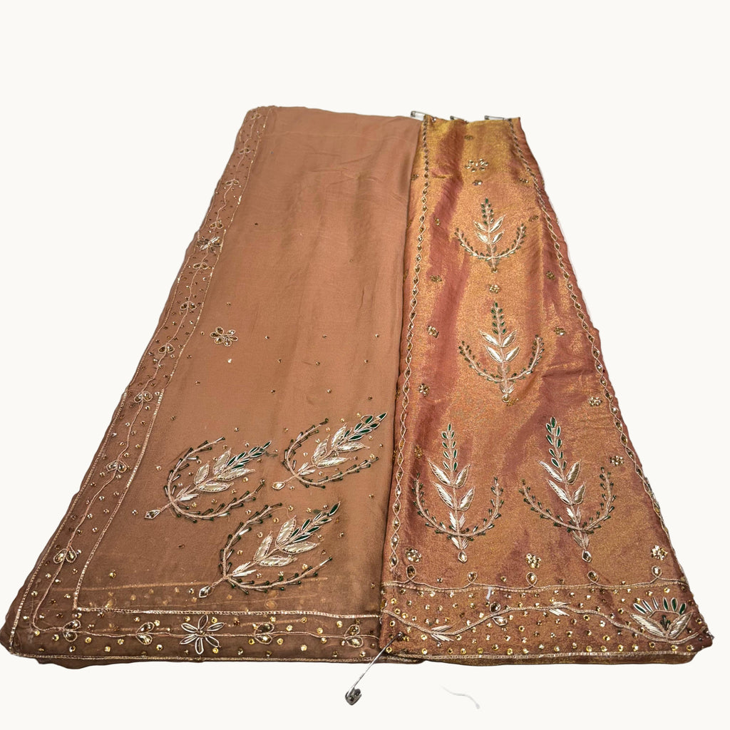 Brown fabric with intricate gold embroidery on a white background
