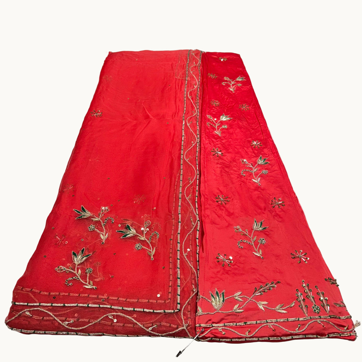 Red embroidered fabric on a white surface