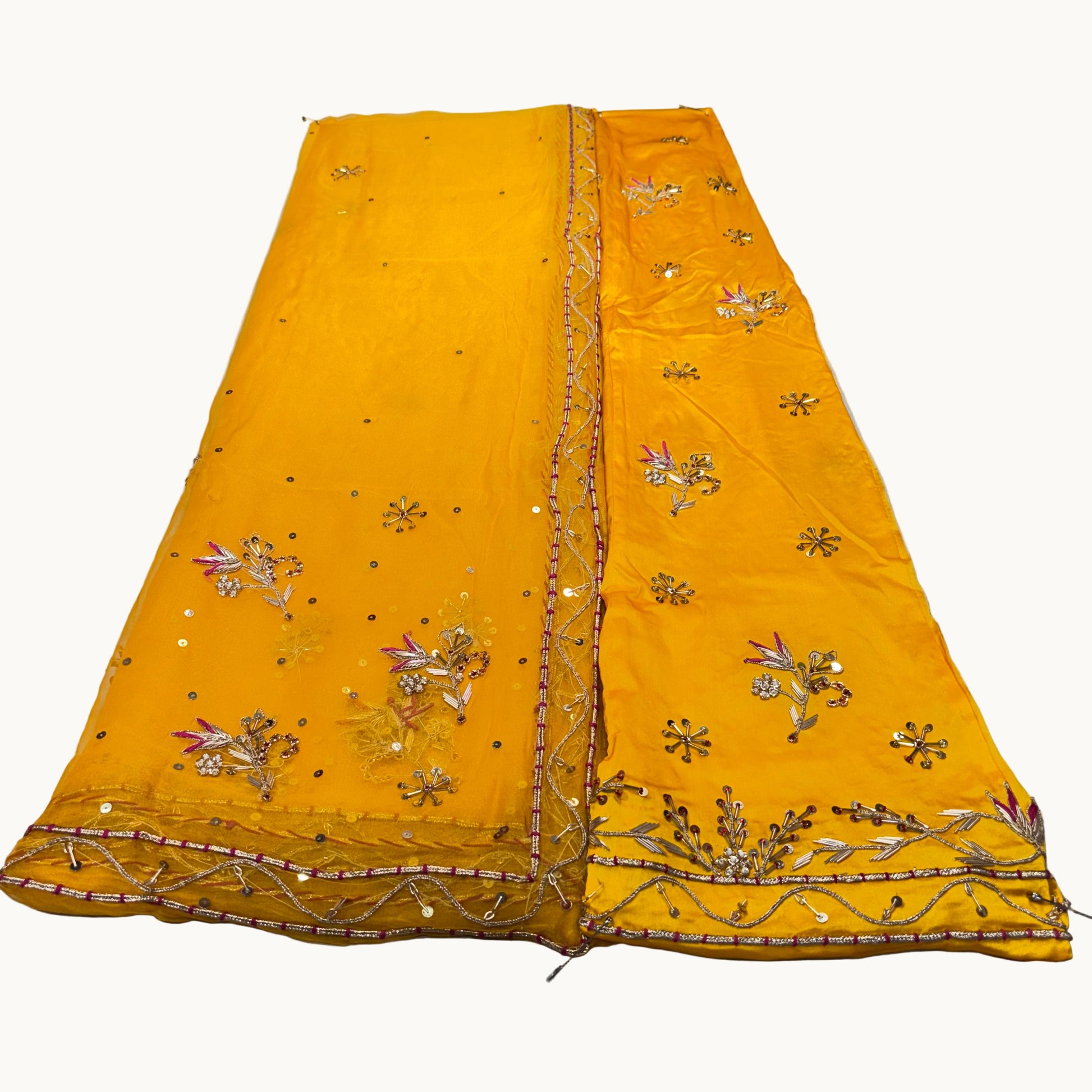 Yellow embroidered fabric on a light gray surface