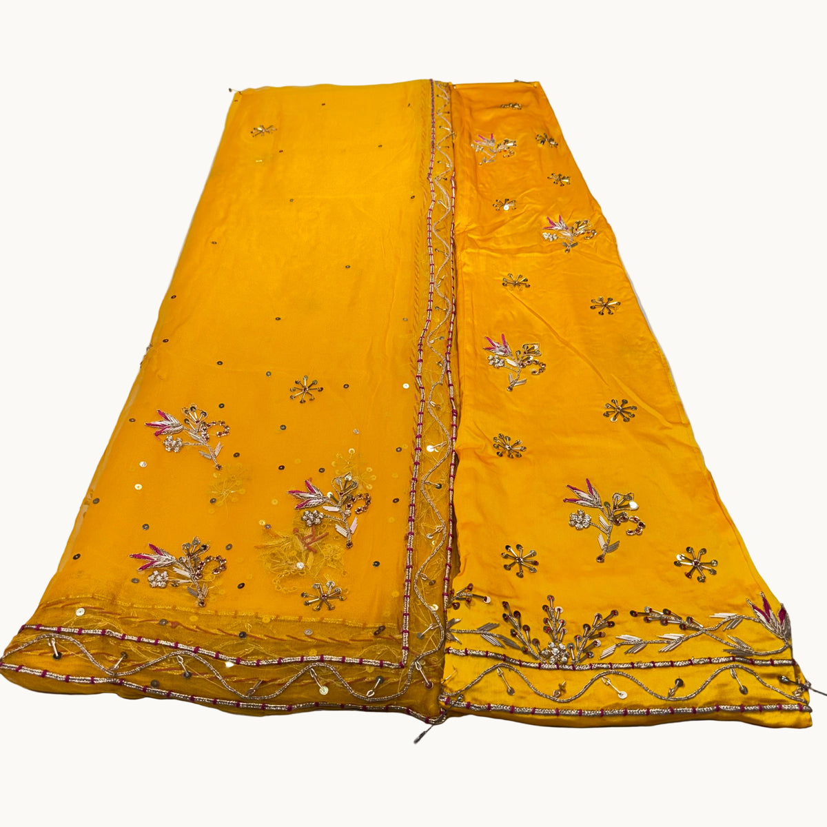 Yellow embroidered fabric on a light gray surface
