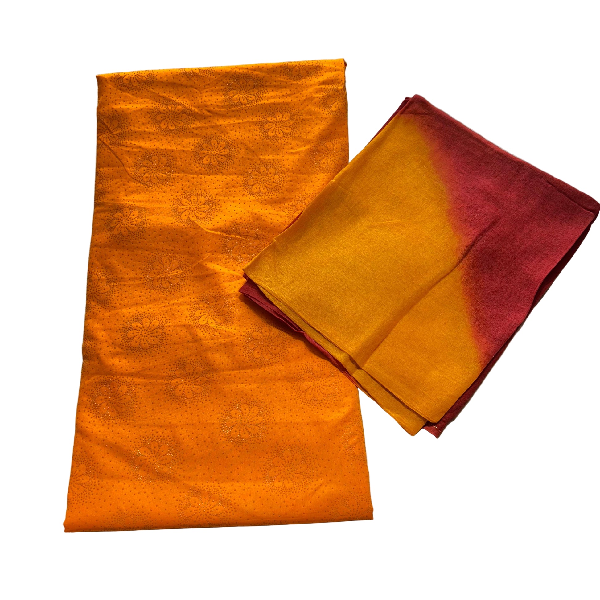 Two folded fabric pieces, one orange and one red and orange gradient, on a textured gray surface.