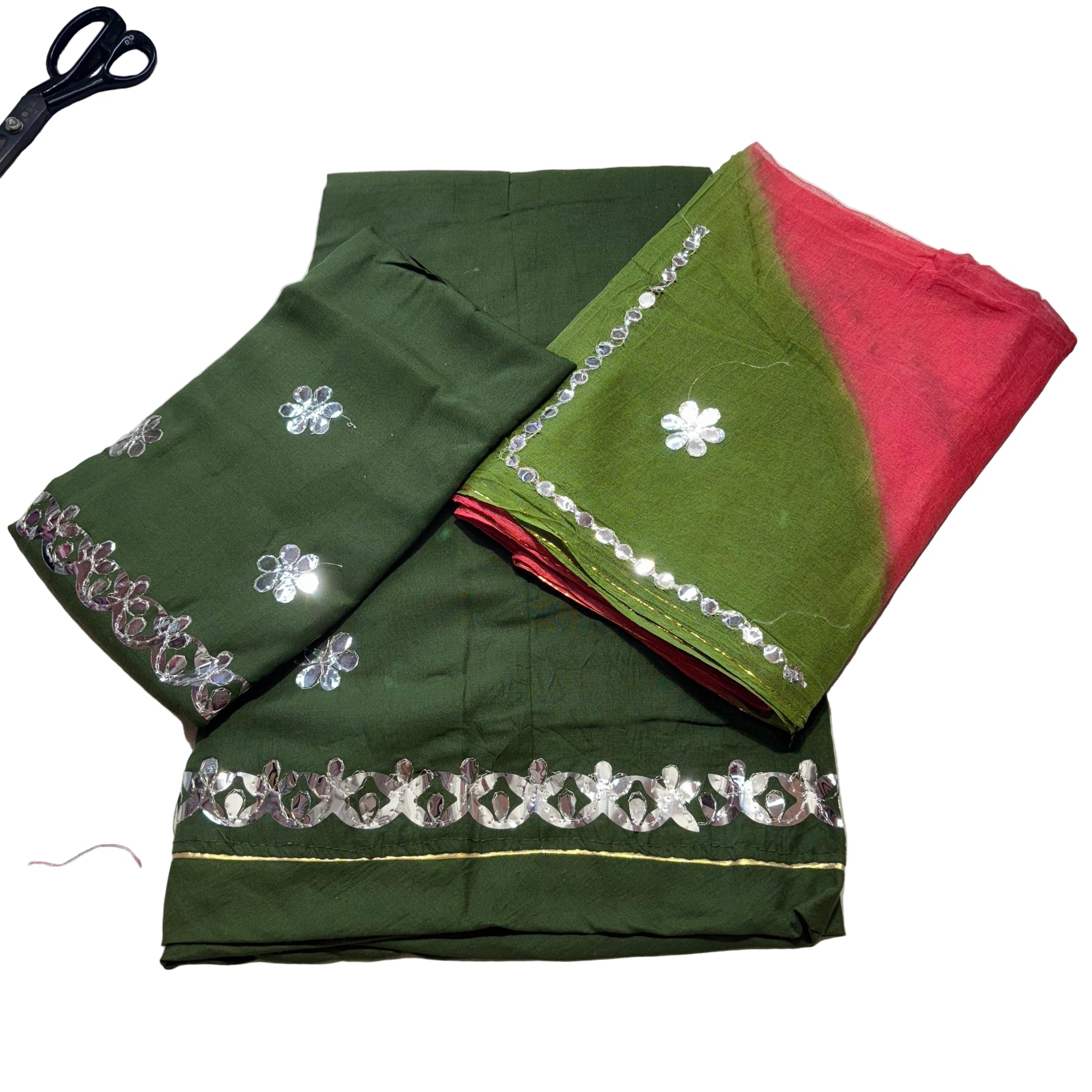 Green and red saree with floral embroidery on a light gray surface.