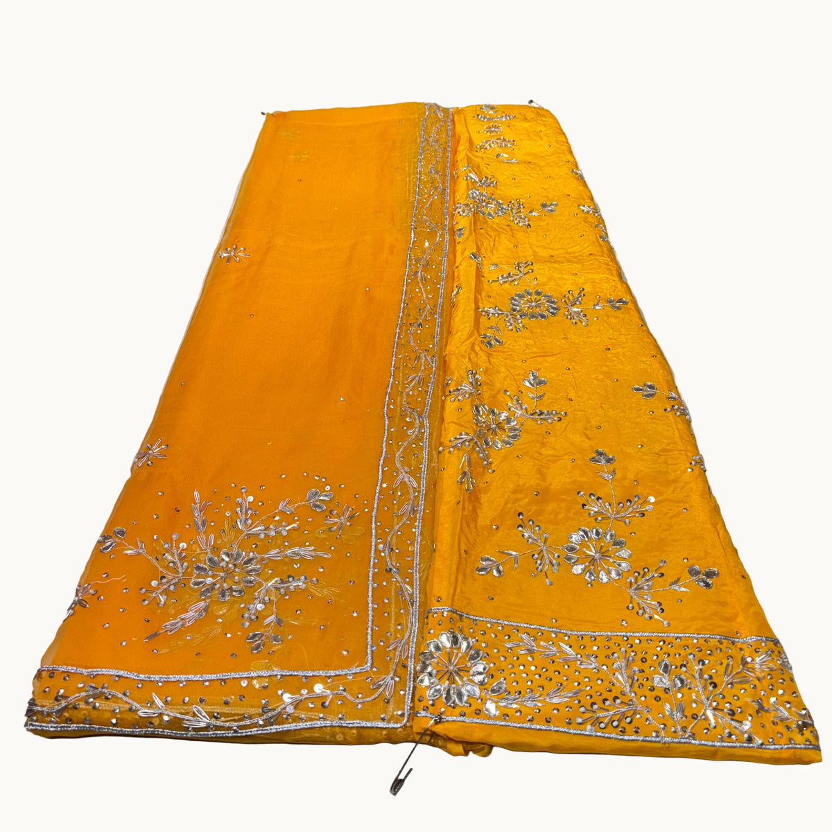Yellow fabric with silver embroidery on a white background