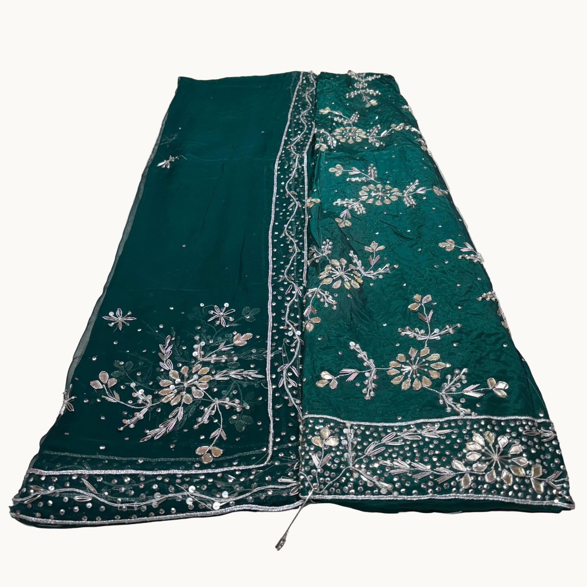 Green embroidered fabric on a white surface