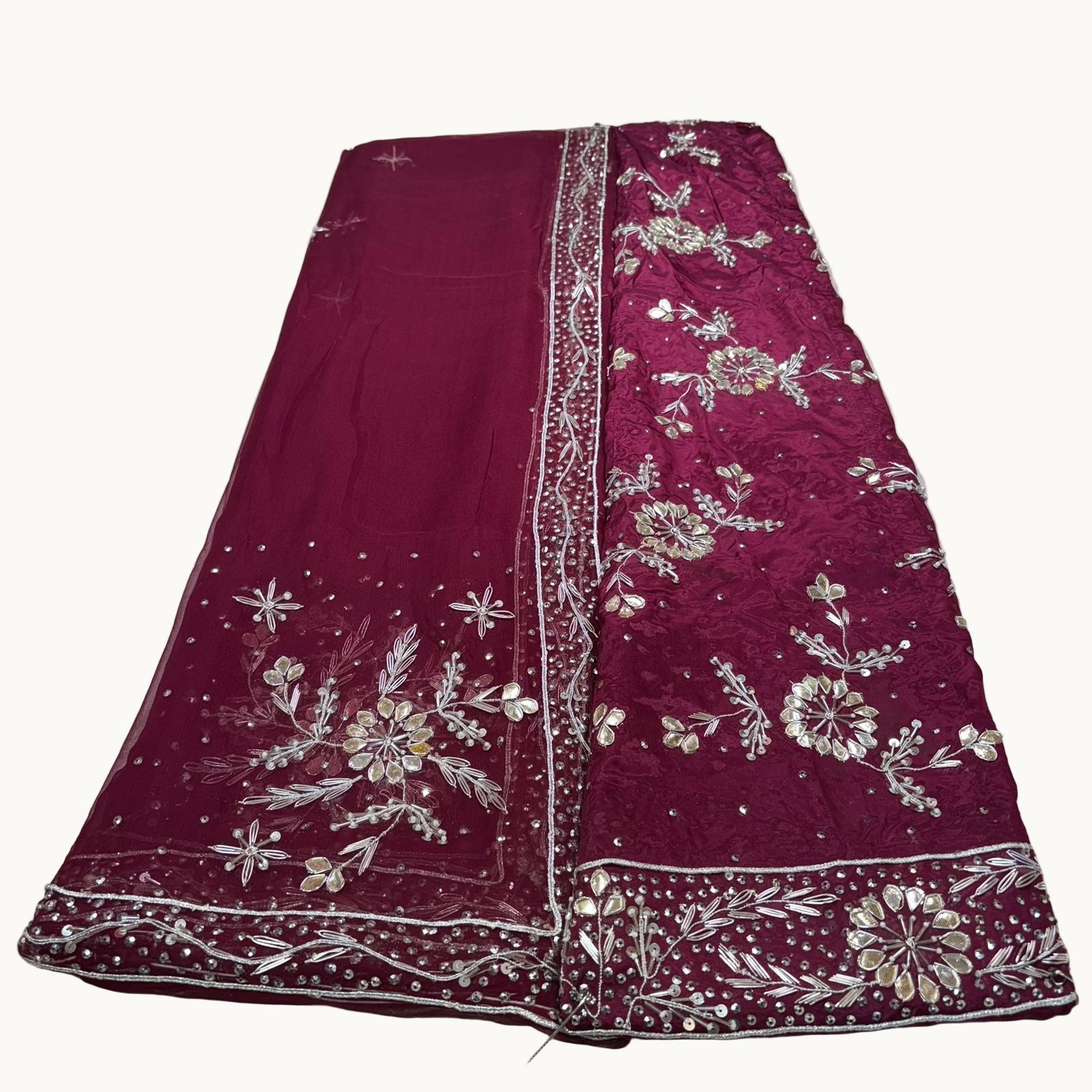 Maroon fabric with floral embroidery on a white background