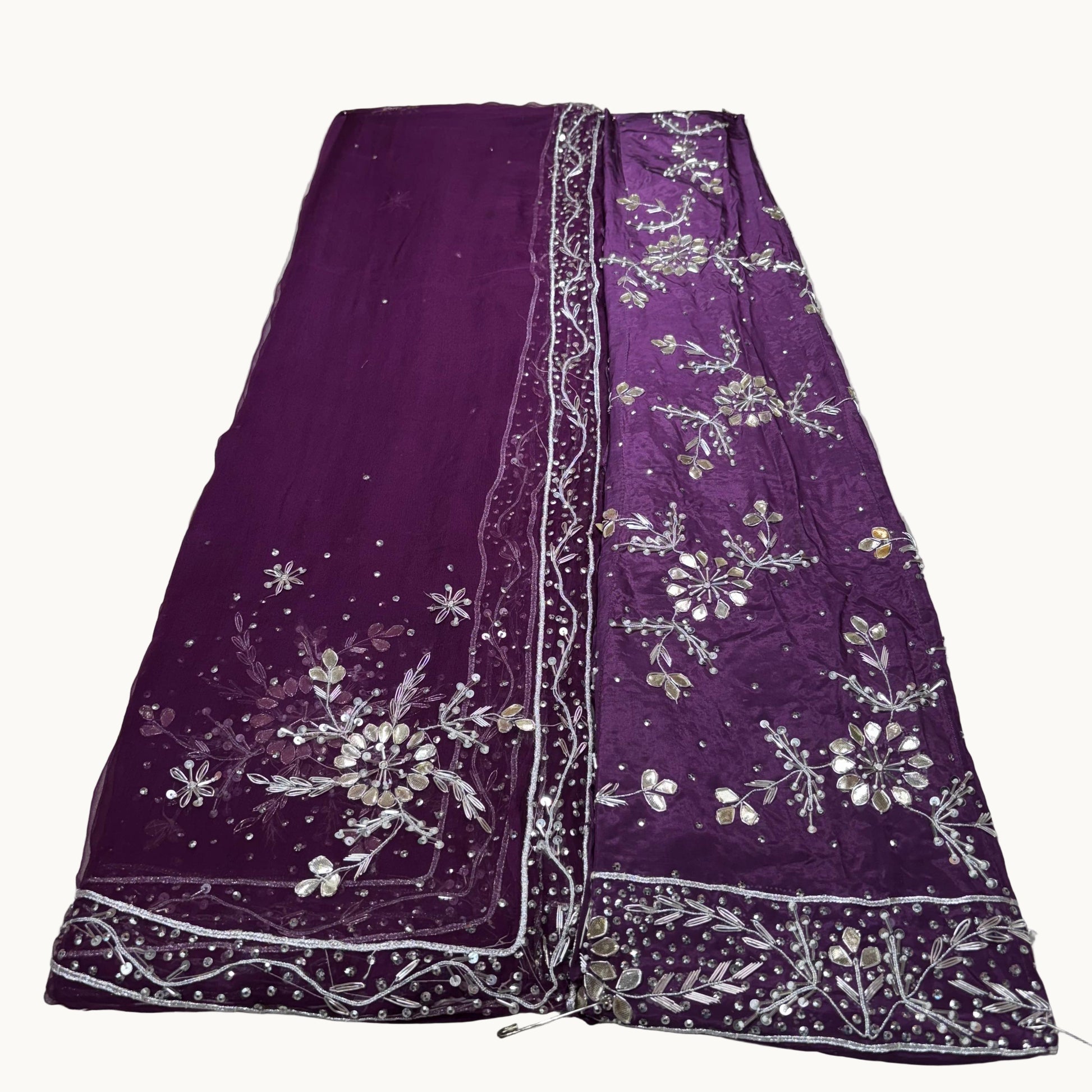 Purple embroidered fabric on a white surface