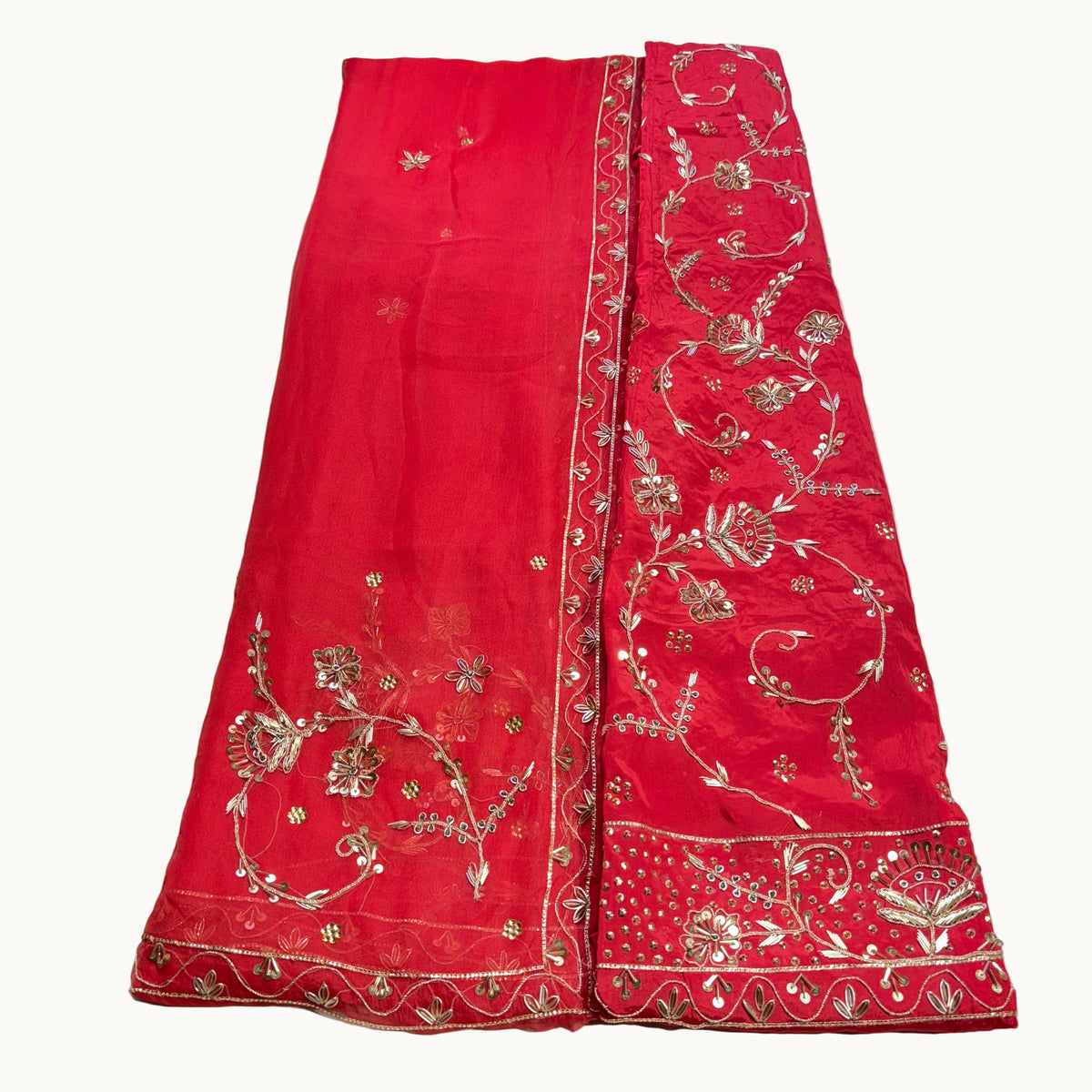 Red fabric with gold embroidery on a light gray background