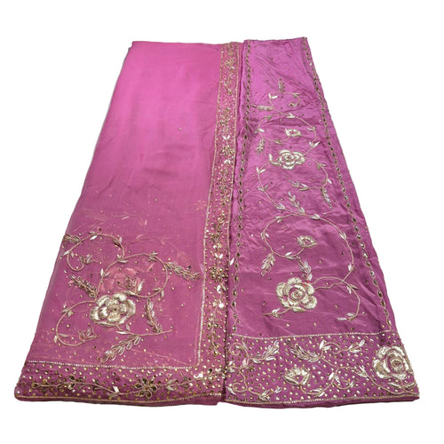 Pink fabric with gold embroidery on a white background