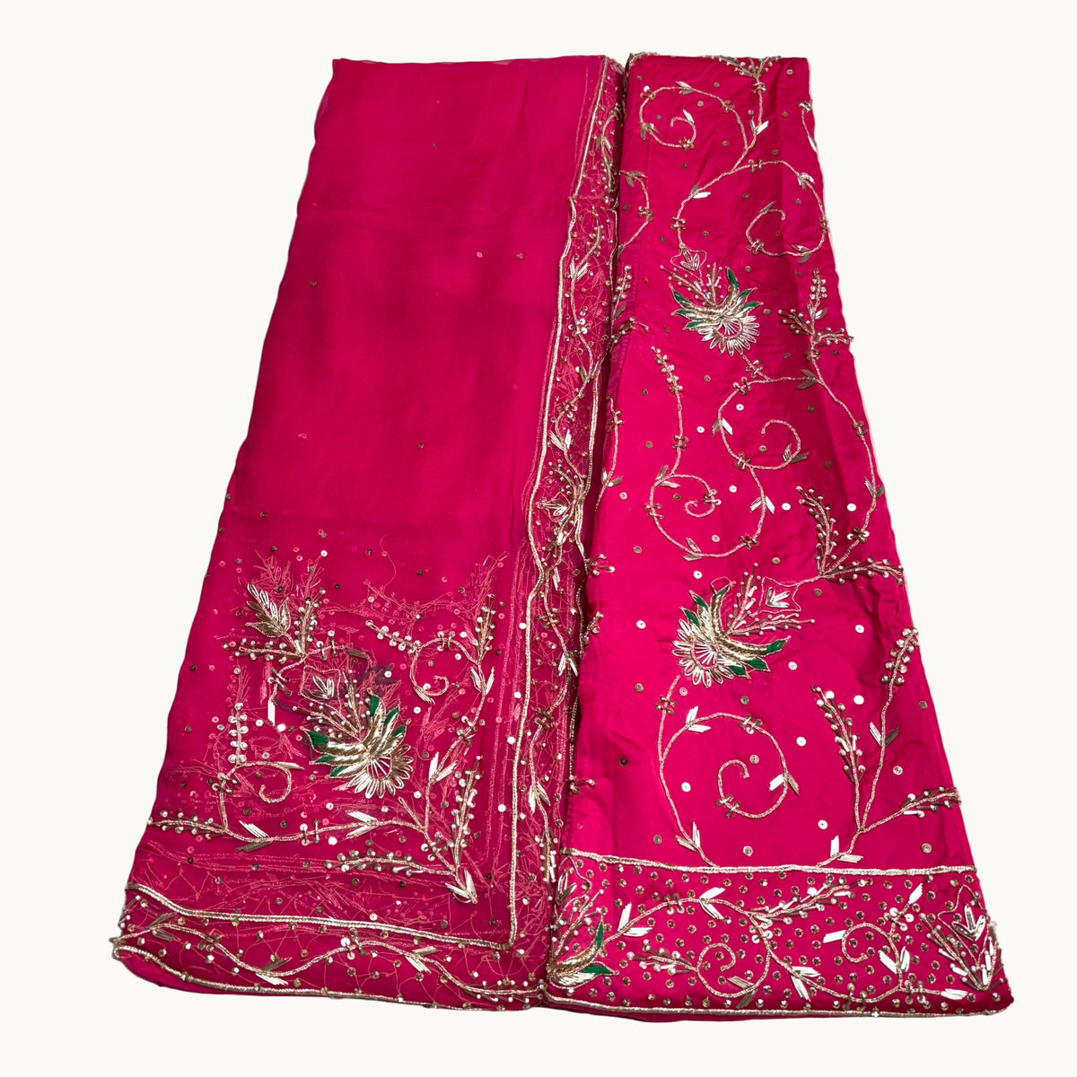 Pink fabric with intricate gold embroidery on a white background