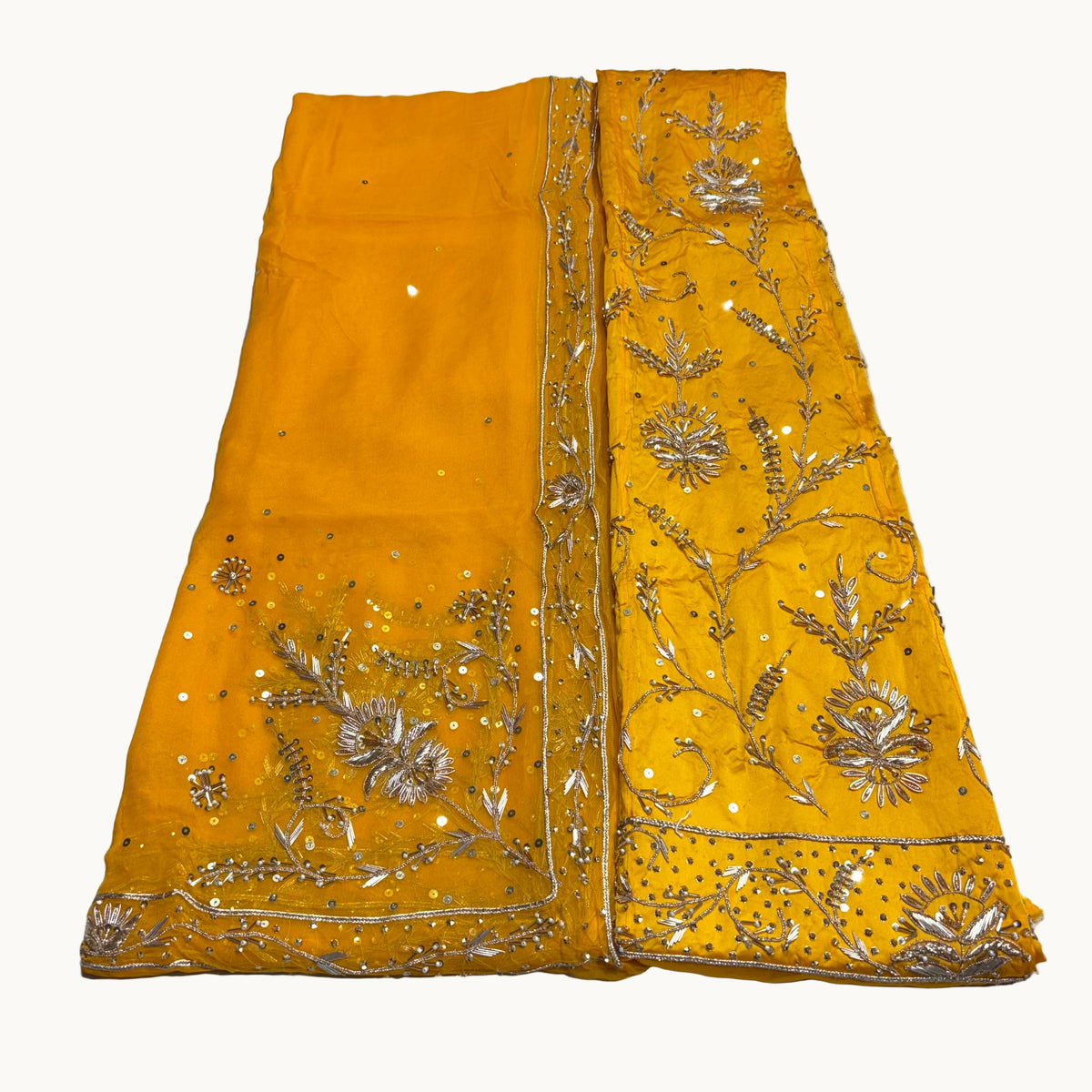Yellow fabric with intricate gold embroidery on a white background