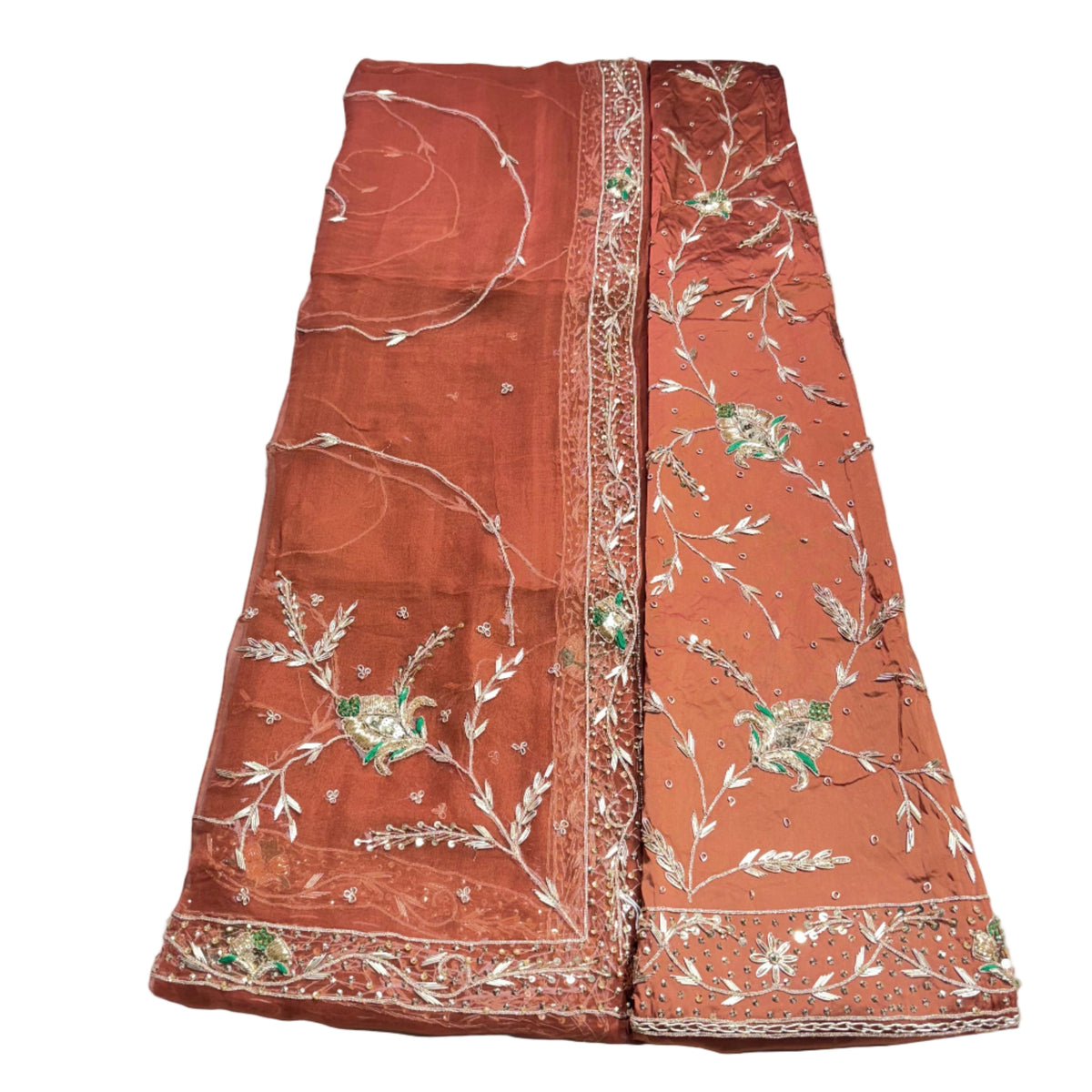 Brown fabric with intricate white and green embroidery on a white surface