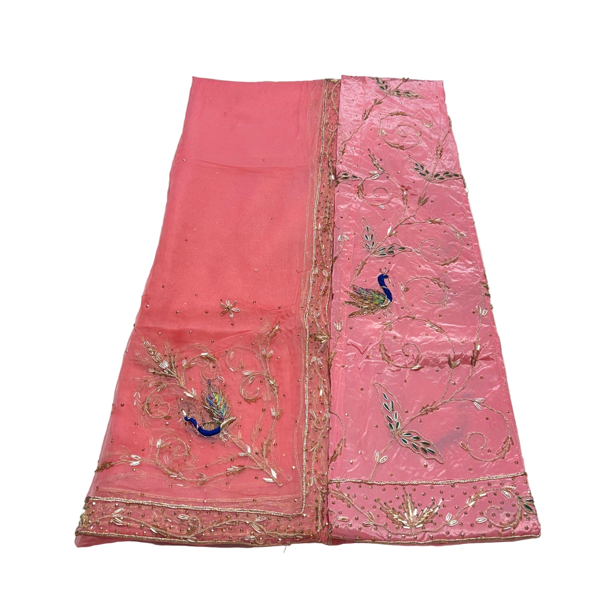 Pink embroidered fabric with peacock designs on a white surface