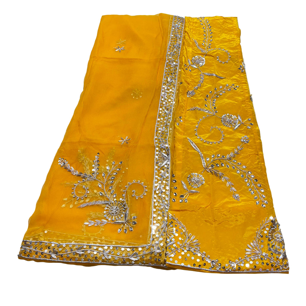 Yellow saree with silver embroidery on a light gray background