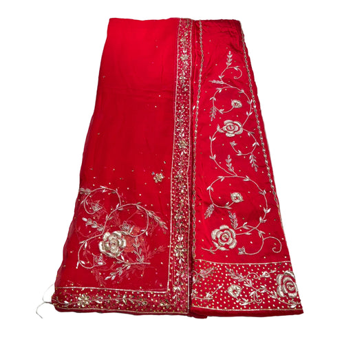 Red fabric with white floral embroidery on a white background